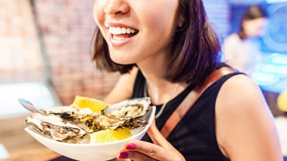 woman holding a bowl of oysters