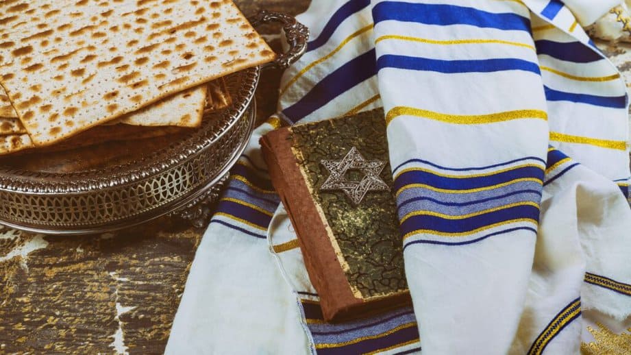 Jewish items on a table with dry bread, torah and scarf
