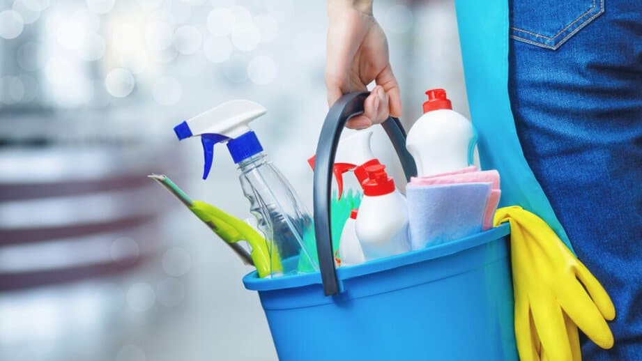 woman holding bucket of cleaning supplies