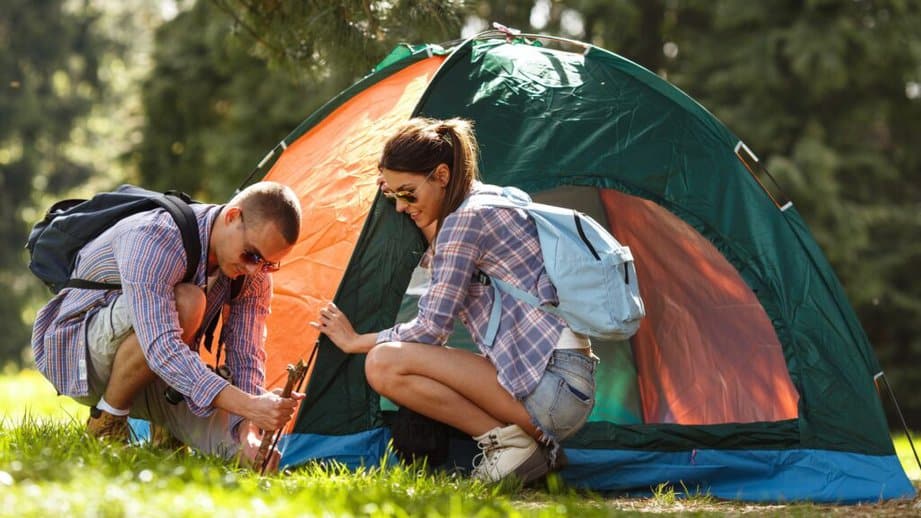 couple setting up tent to go camping