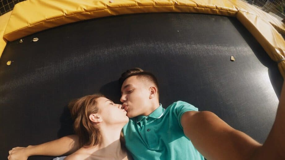 couple kissing on a trampoline