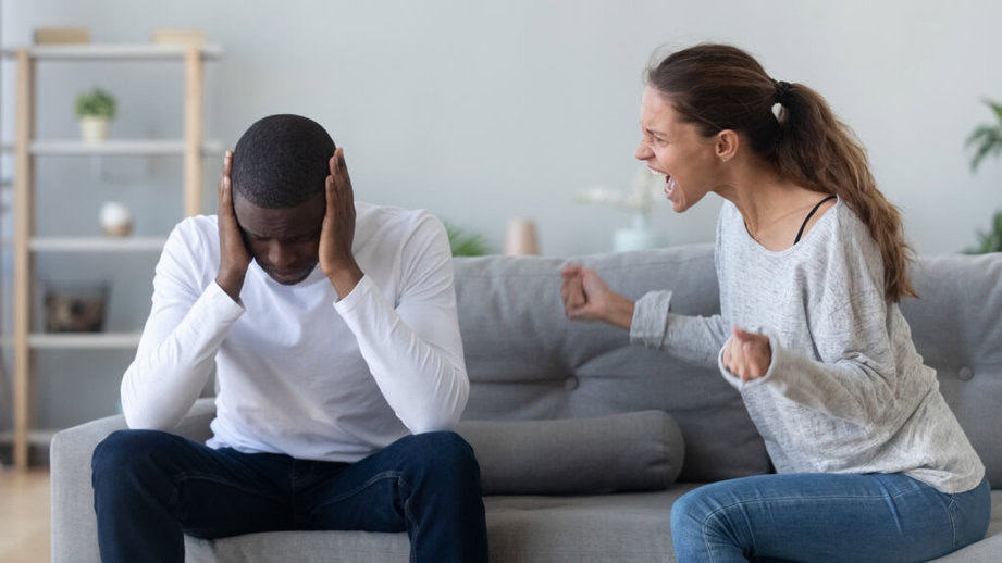 woman yelling at boyfriend on couch