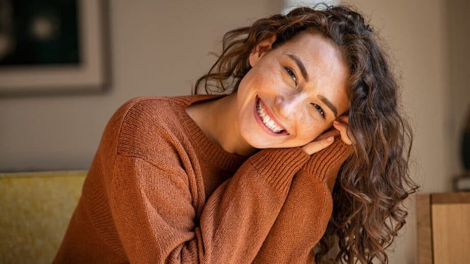 happy, smiling woman in a brown sweater