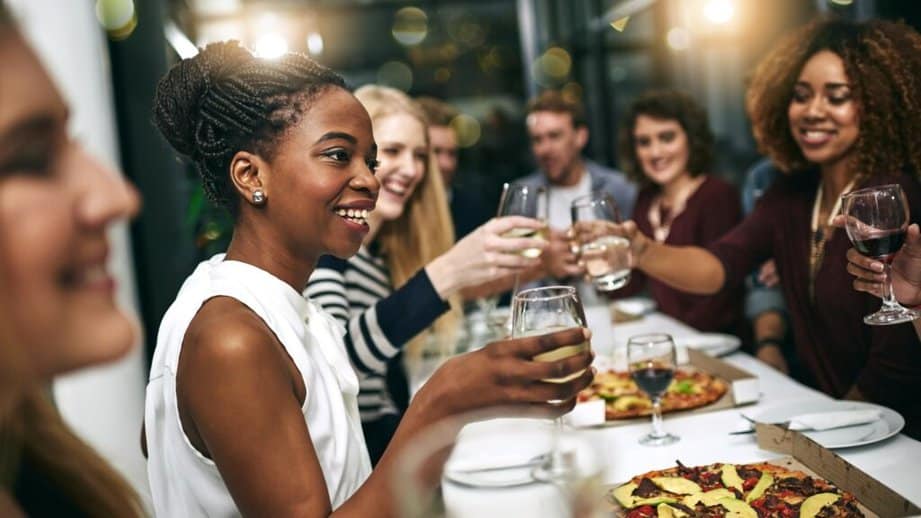woman sitting at a dinner party with wine