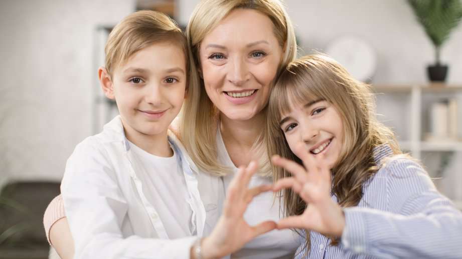 daughter with son and mother join hands in shape of heart
