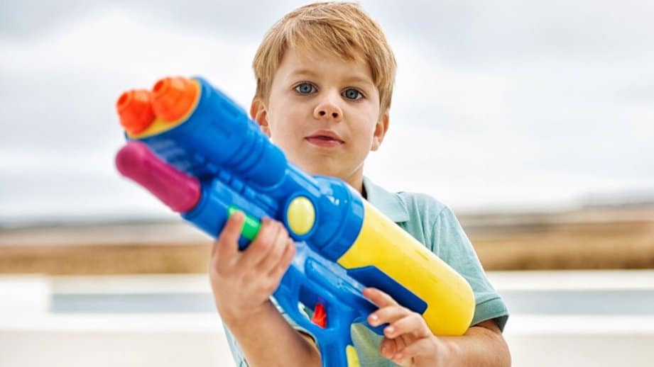 kid with super soaker water gun