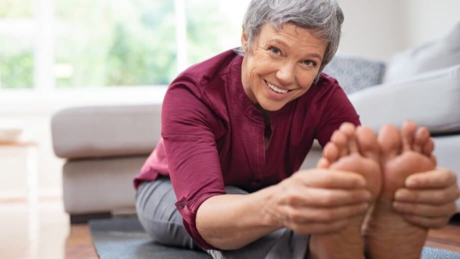 mature senior doing Yoga grabbing toes