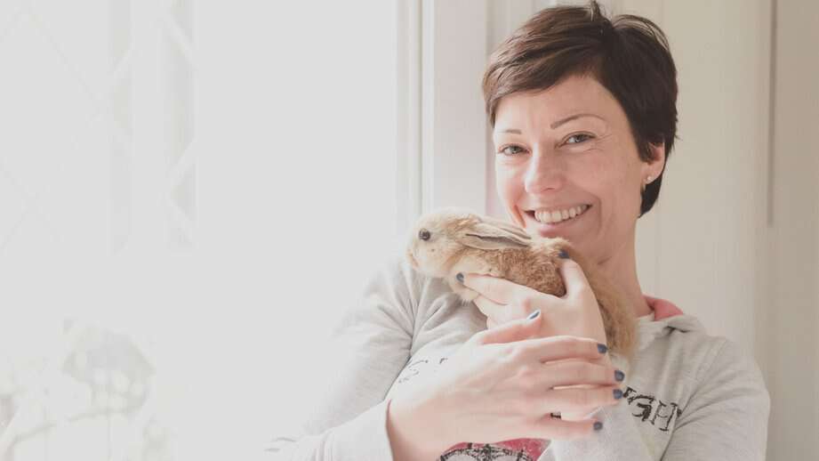 middle aged woman holding bunny rabbit pets