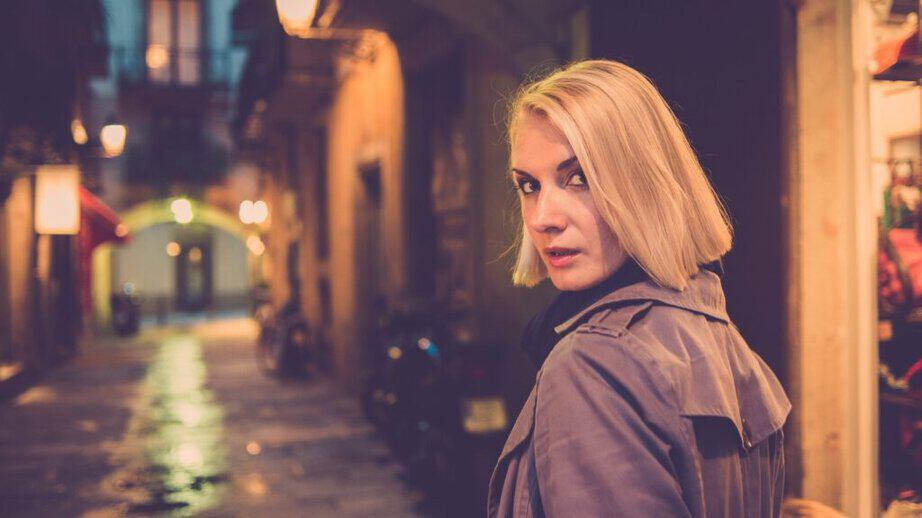 woman walking alone at night in a coat