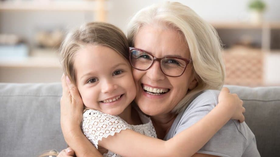 grandma hugging grand daughter and smiling