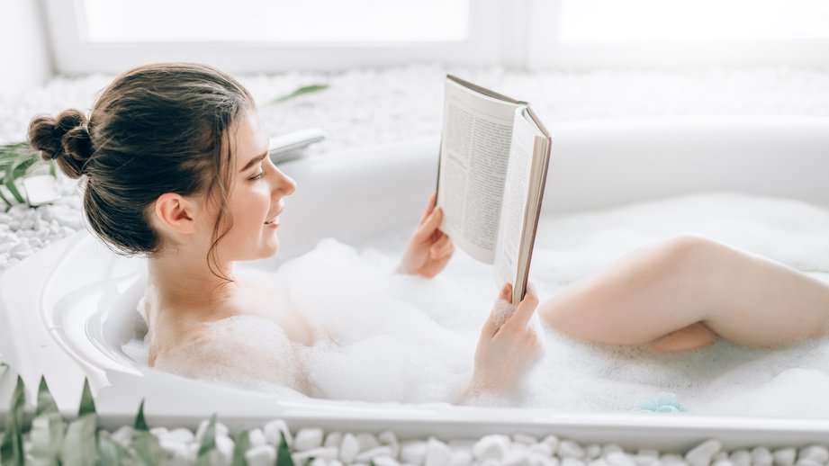 woman reading a book in a bubble bath