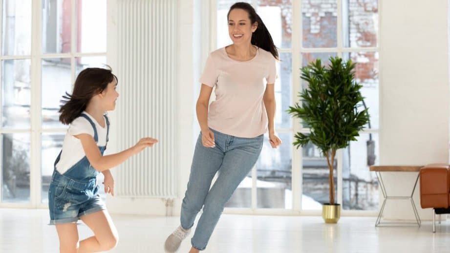 mom playing tag with her daughter inside the house