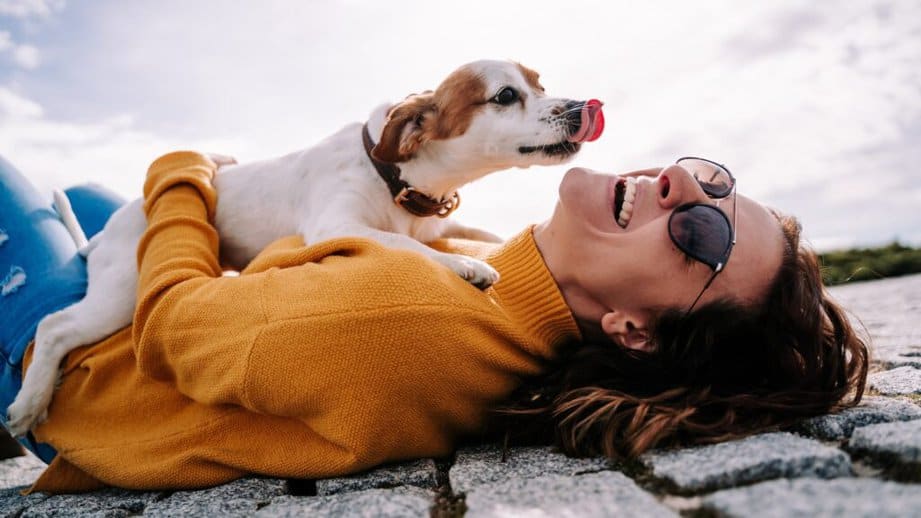 woman laying on the ground with a dog