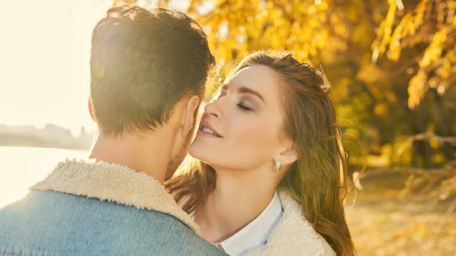 woman whispering to a man outside