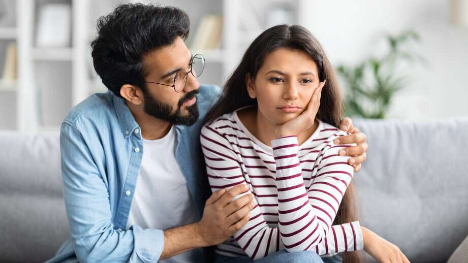 couple sitting on couch unhappy