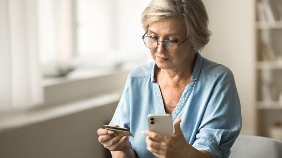 older woman making a purchase on a credit card