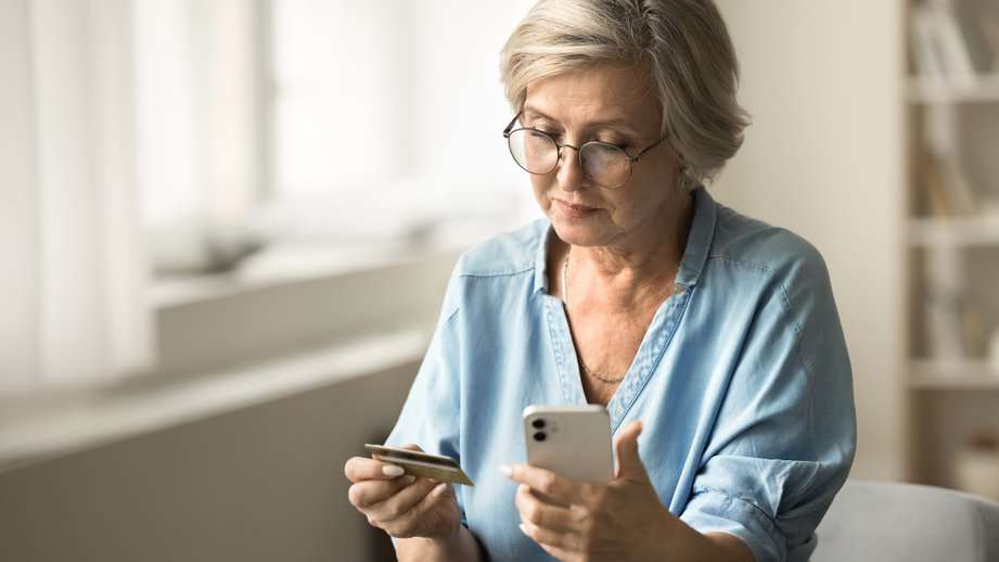 older woman making a purchase on a credit card