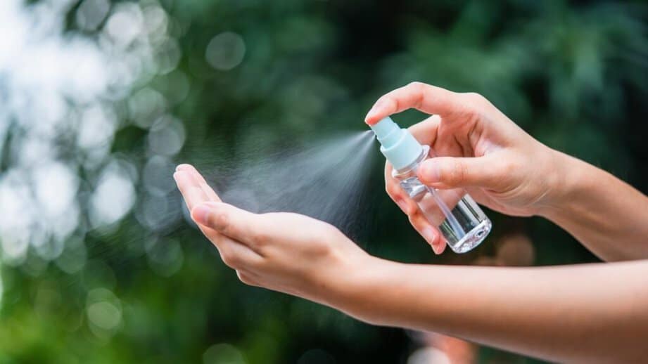 spraying hands with sanitizer spray