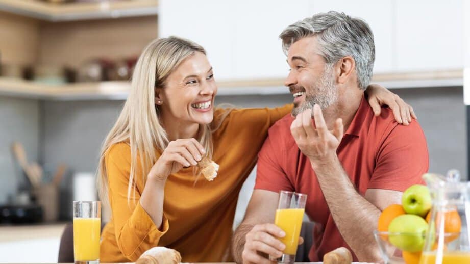 happy couple smiling and eating breakfast