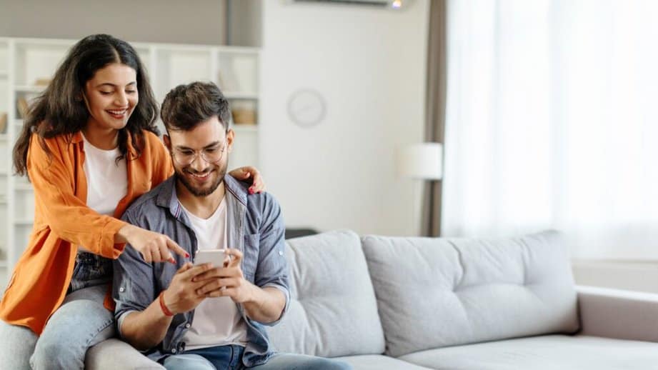 couple looking at phone on a couch